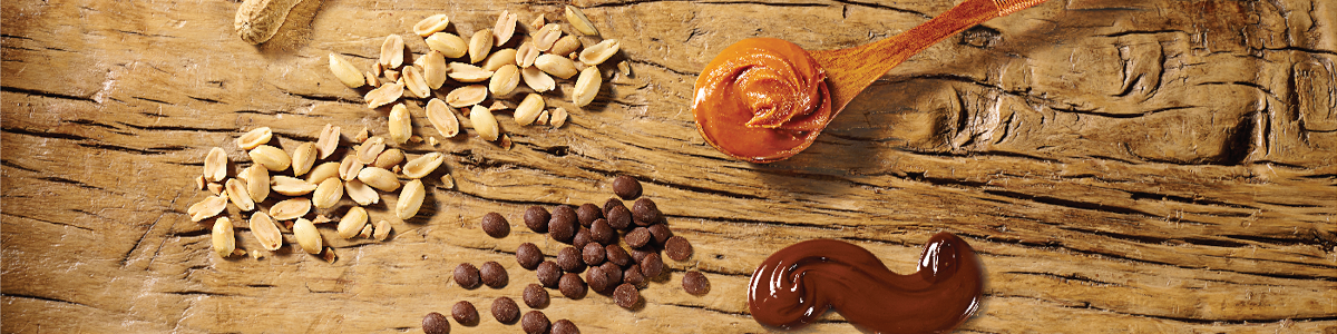 peanuts, chocolate and peanut butter ingredients on a wooden board