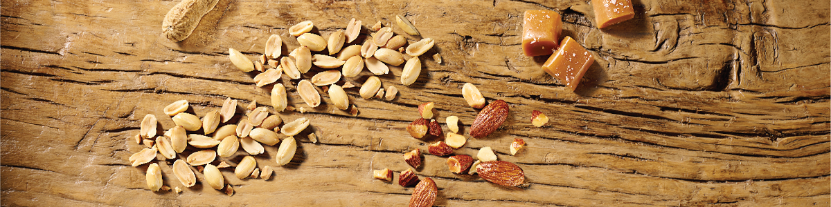 peanutes, almonds and caramel ingredients on wooden board