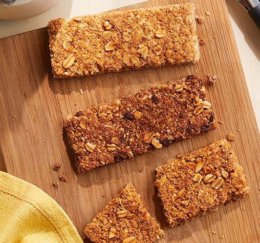 three Nature Valley crunchy granola bars unwrapped on a wooden board